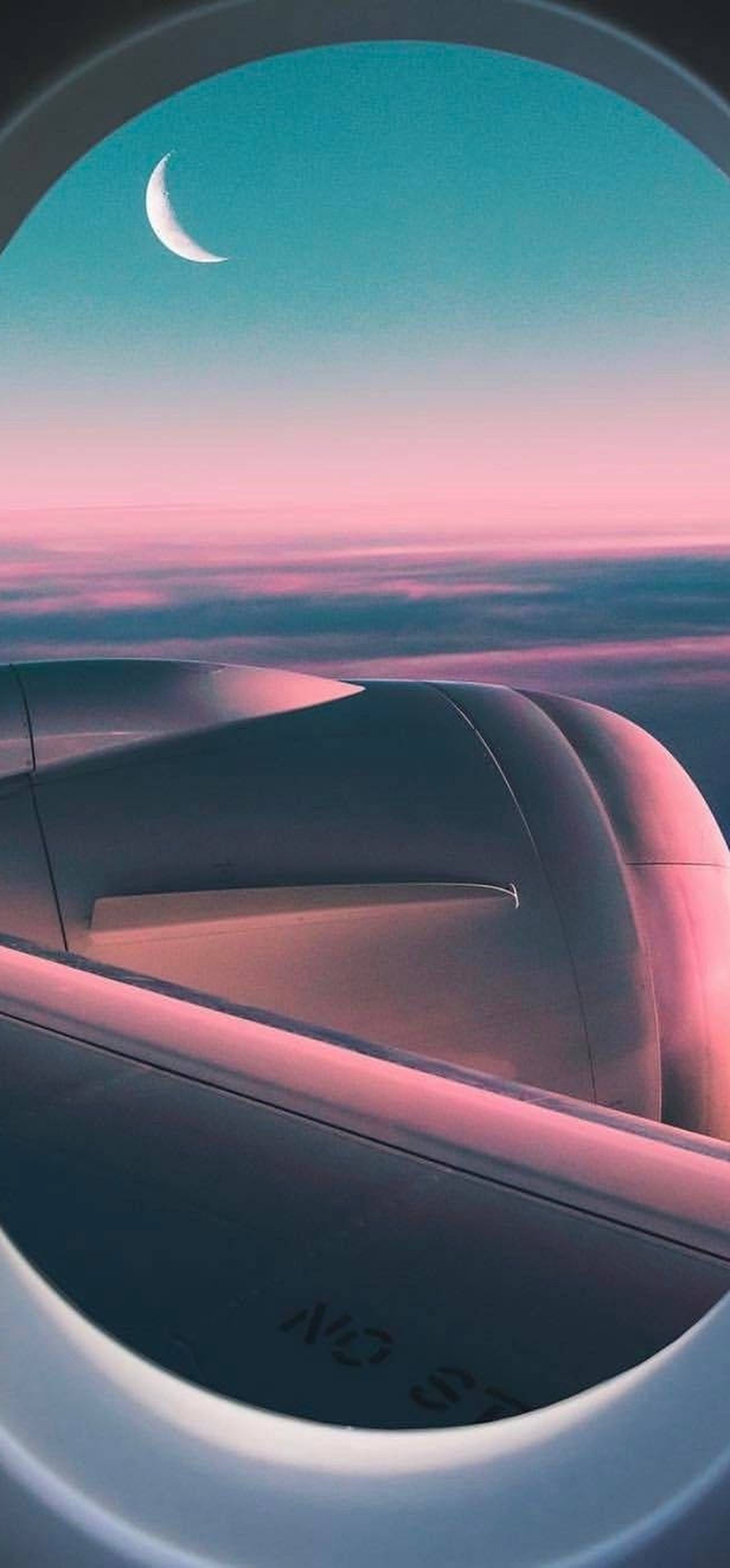 Airplane wing seen from window during twilight with crescent moon
