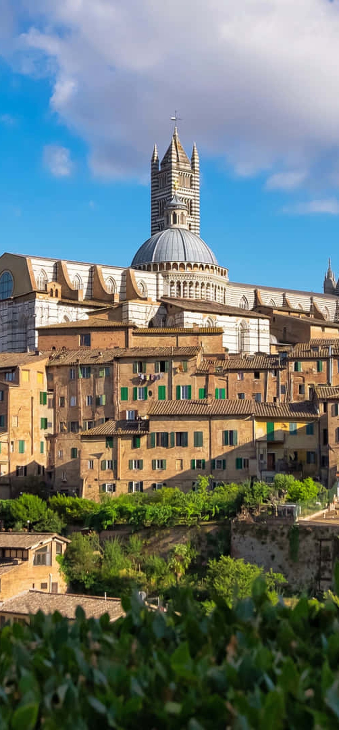Historic hillside town with cathedral under bright blue sky