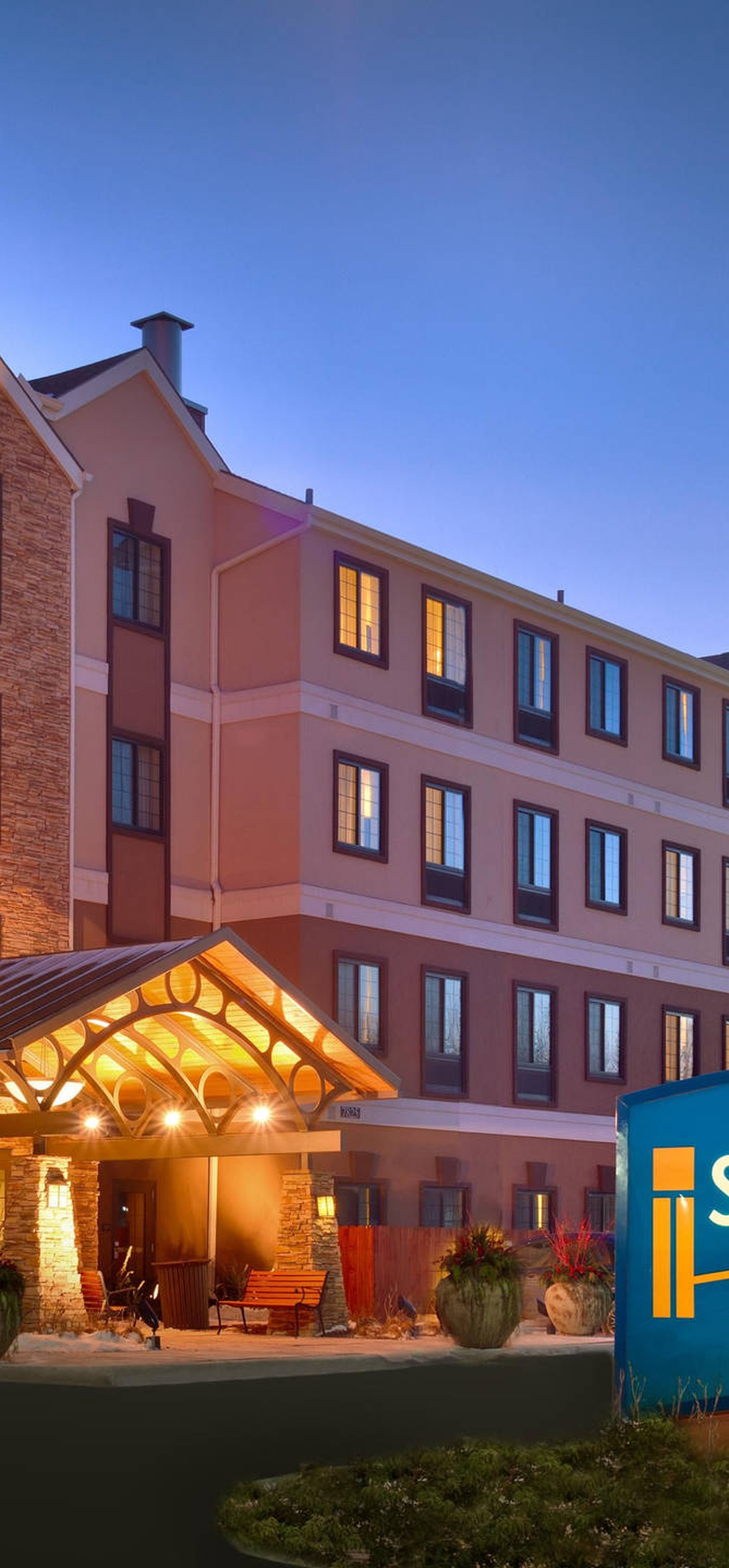 Staybridge Suites hotel at dusk with illuminated windows and entrance canopy.