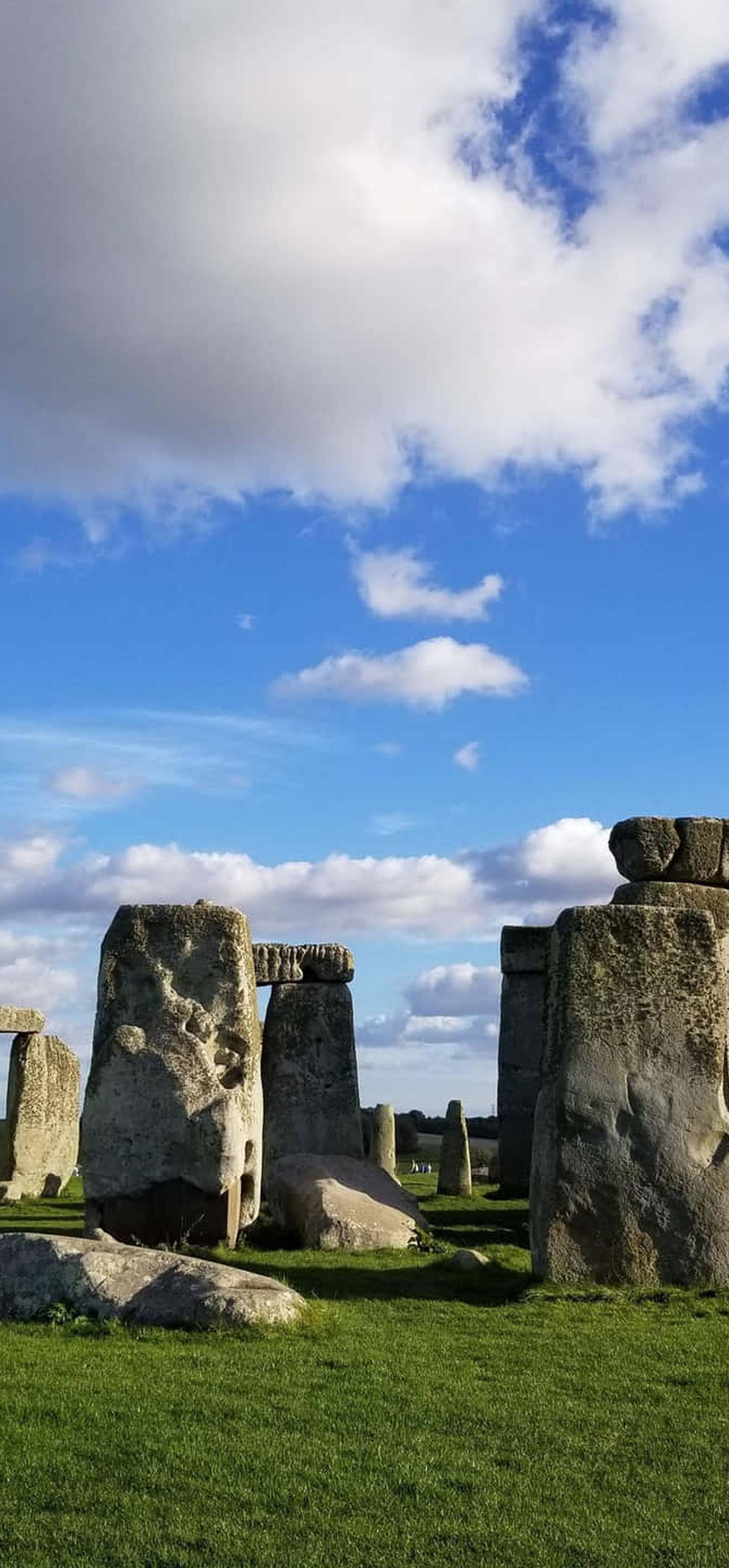 Stonehenge ancient stone circle under blue sky with white clouds